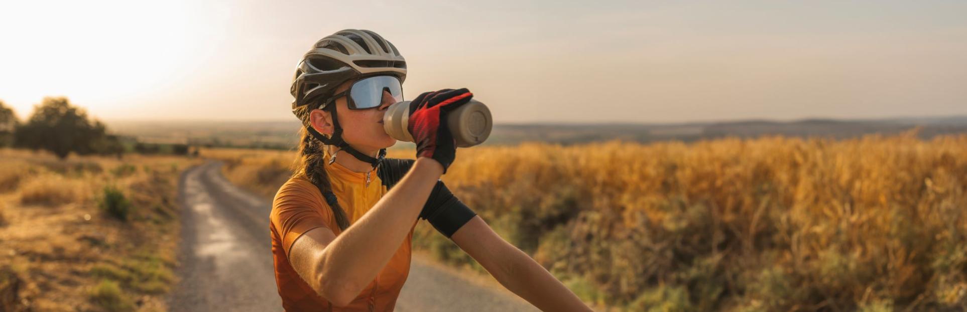 woman on bike drinking water