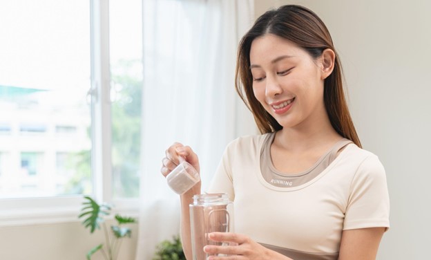 woman pouring protein powder