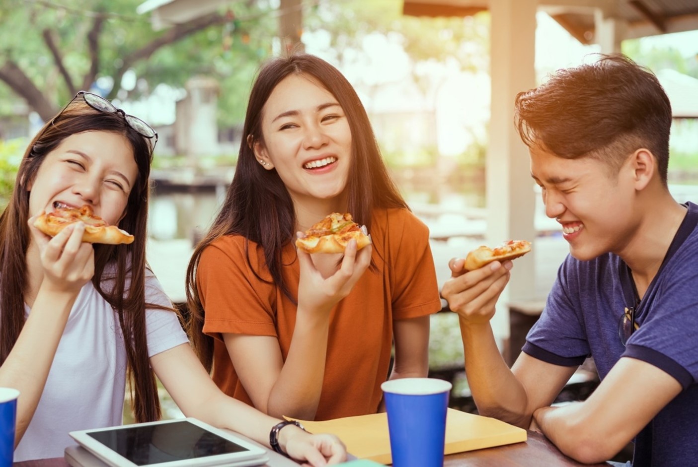 three people eating pizza