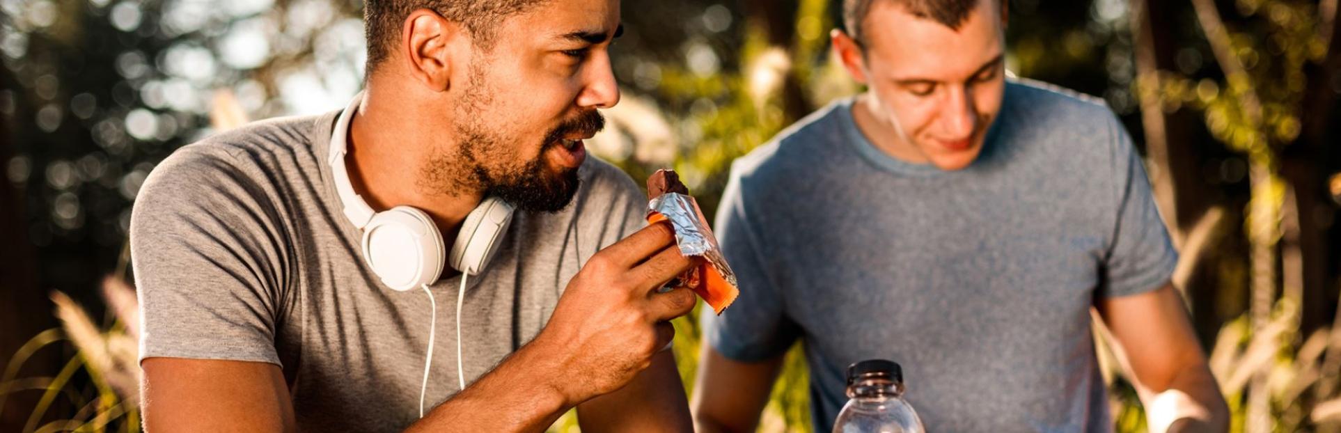 two men with nutritional bar and drink